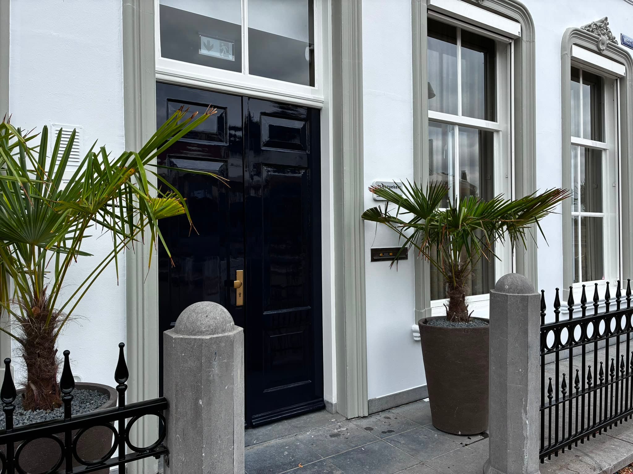 Zijaanzicht van de entree van een monumentaal pand met hoogglans gelakte voordeur en gerenoveerde gevel, Mourits Schilderwerken